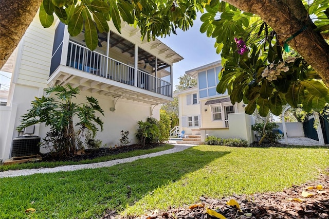 exterior space featuring fence, a lawn, cooling unit, and a balcony