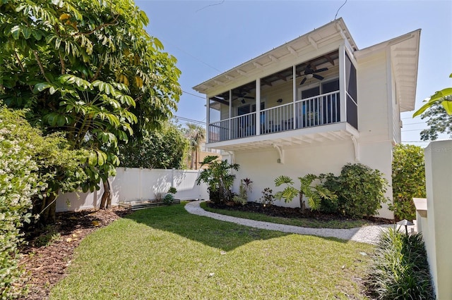 view of front of property featuring a front lawn, a ceiling fan, and fence