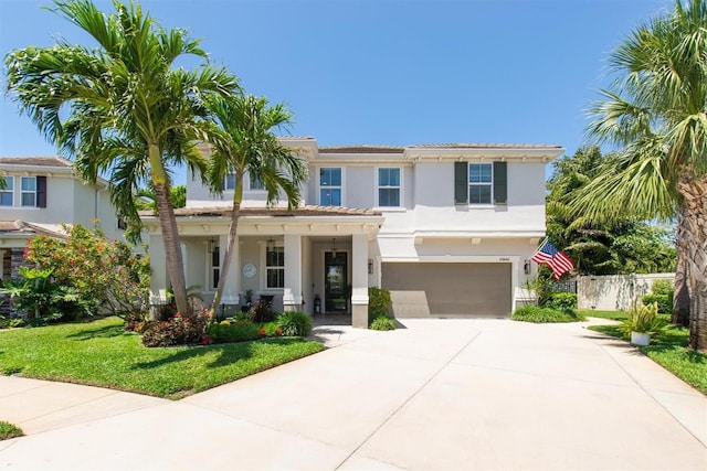 view of front of property featuring a porch, an attached garage, driveway, stucco siding, and fence