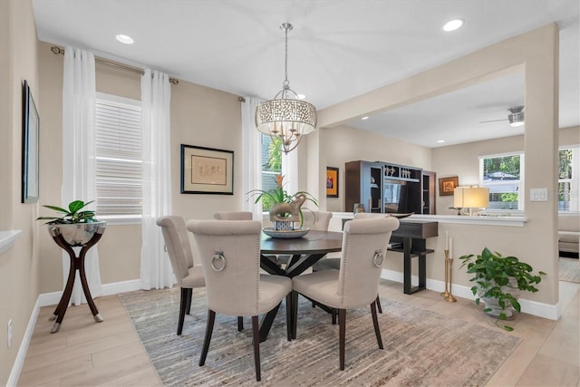 dining area with a chandelier, recessed lighting, wood finished floors, and baseboards