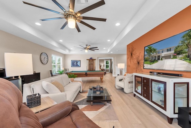 living room featuring recessed lighting, a raised ceiling, light wood finished floors, and pool table