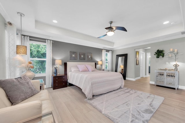 bedroom featuring recessed lighting, wood finished floors, ceiling fan, baseboards, and a tray ceiling