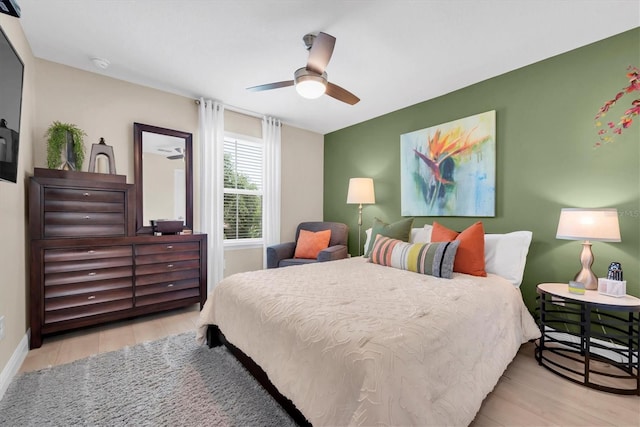bedroom with baseboards, wood finished floors, and ceiling fan