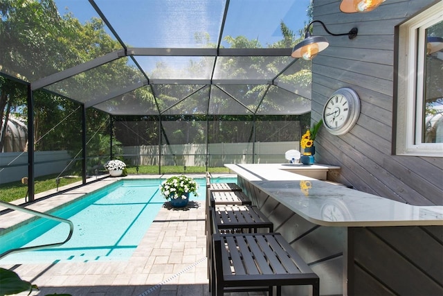 view of pool with a lanai, outdoor dry bar, a patio area, and a fenced in pool