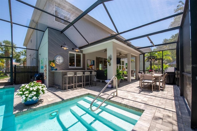 view of swimming pool featuring glass enclosure, a ceiling fan, outdoor dry bar, and a patio area