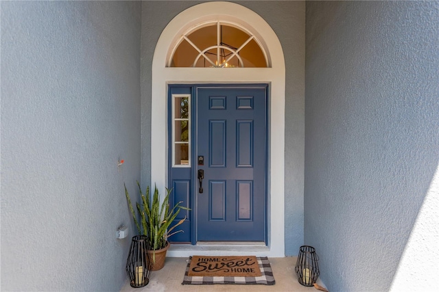 view of exterior entry featuring stucco siding