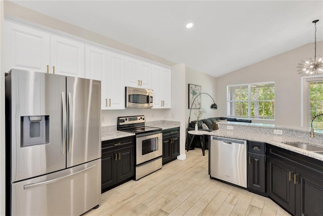 kitchen with white cabinets, a sink, appliances with stainless steel finishes, and dark cabinetry