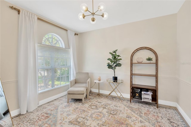 sitting room featuring an inviting chandelier and baseboards