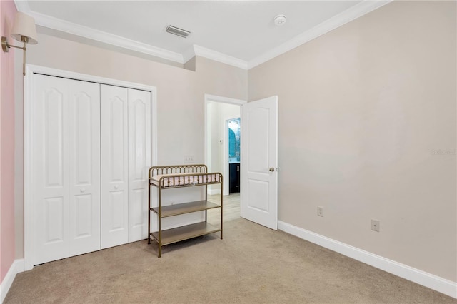 bedroom with visible vents, a closet, baseboards, ornamental molding, and light carpet