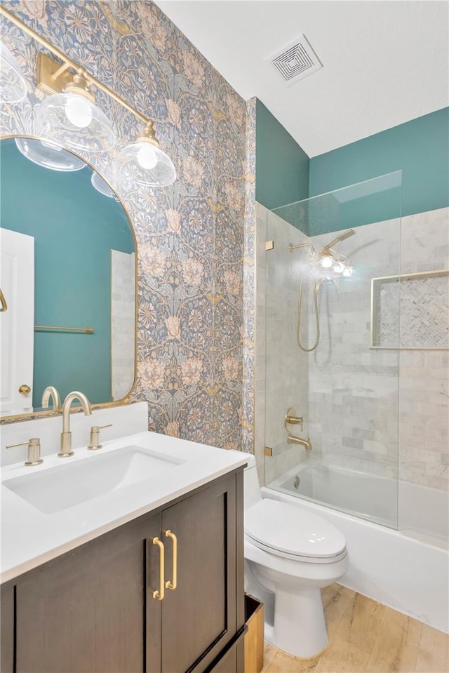 full bathroom featuring vanity, toilet, visible vents, bathtub / shower combination, and wallpapered walls