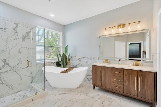 full bathroom with tile walls, a marble finish shower, marble finish floor, a freestanding bath, and double vanity