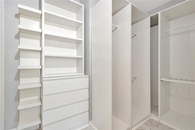 spacious closet featuring marble finish floor