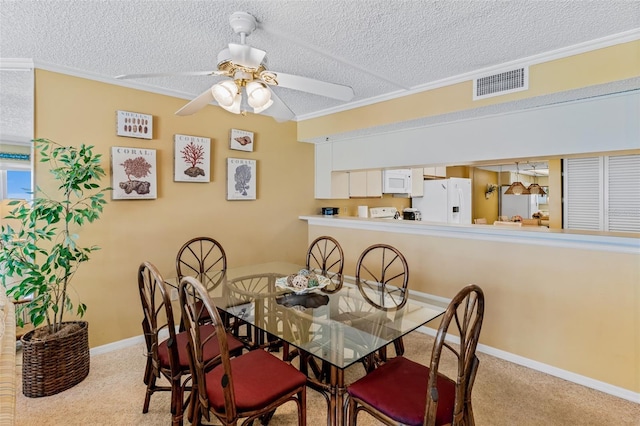 18400 Gulf Blvd Unit 1109, Indian Shores, FL 33785 - dining room featuring carpet, ornamental molding, a ceiling fan, a textured ceiling, and baseboards