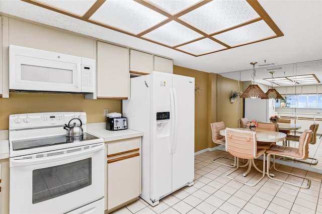 18400 Gulf Blvd Unit 1109, Indian Shores, FL 33785 - kitchen with white appliances, light countertops, light tile patterned floors, white cabinetry, and decorative light fixtures
