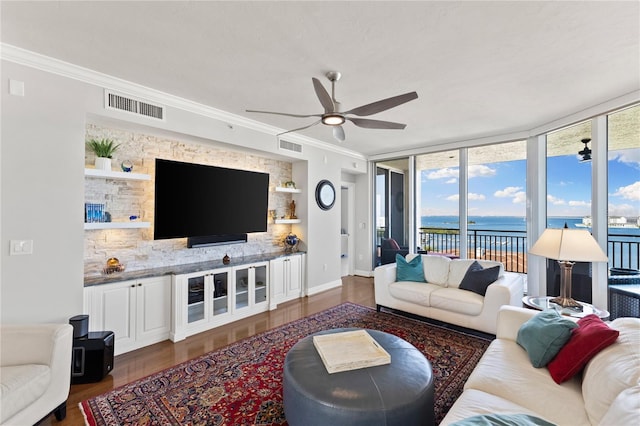 living area featuring visible vents, wood finished floors, a ceiling fan, and crown molding