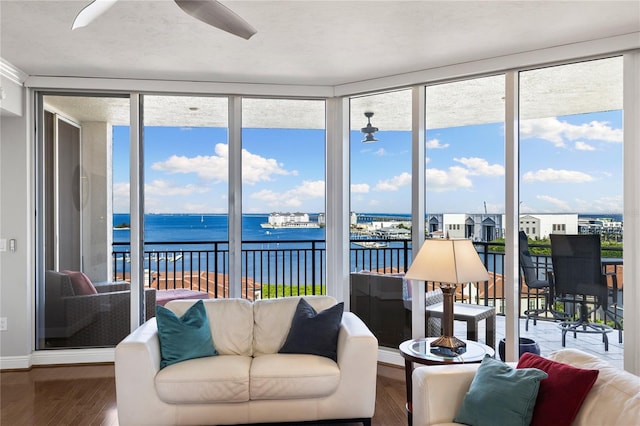 sunroom featuring a water view