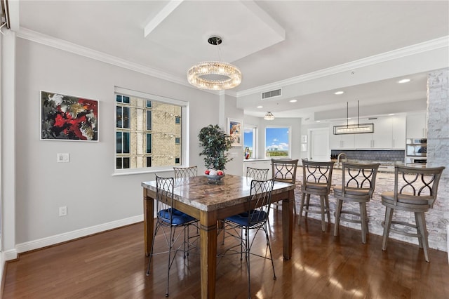 dining space with a notable chandelier, crown molding, visible vents, baseboards, and wood finished floors