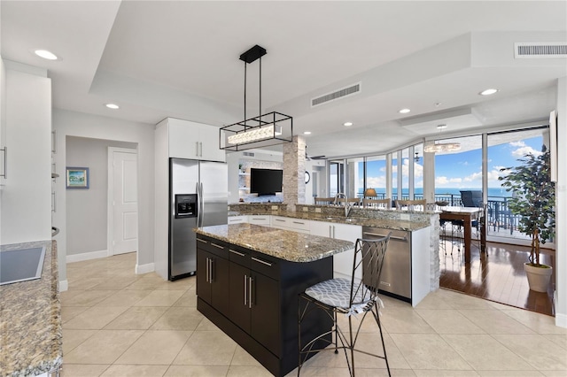 kitchen featuring recessed lighting, light tile patterned floors, appliances with stainless steel finishes, a center island, and visible vents