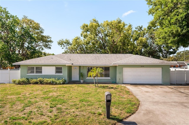 ranch-style home featuring a garage, a front lawn, and fence
