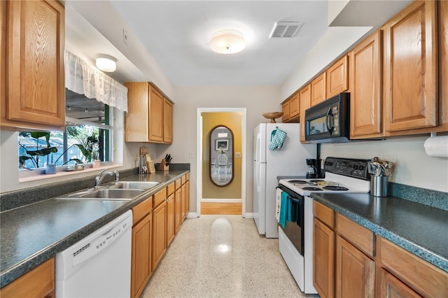 kitchen featuring dark countertops, a sink, white appliances, baseboards, and visible vents