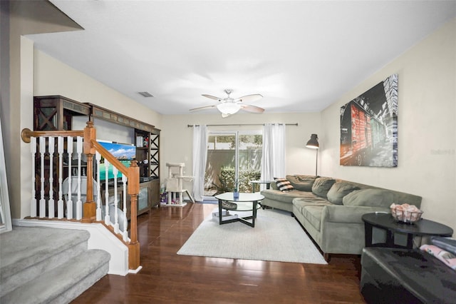 living room with ceiling fan, visible vents, wood finished floors, and stairway