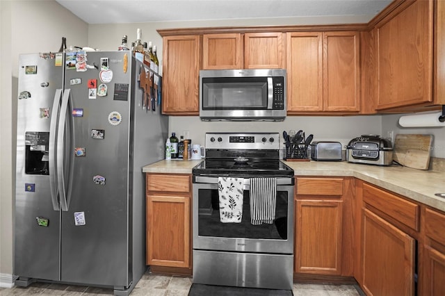 kitchen featuring light countertops, appliances with stainless steel finishes, and brown cabinetry