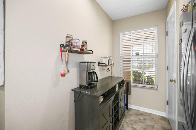 interior space with baseboards and light tile patterned floors