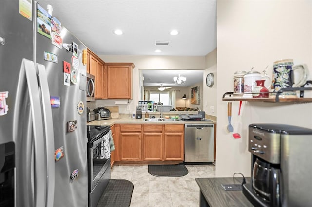kitchen featuring brown cabinetry, visible vents, a sink, light countertops, and stainless steel appliances
