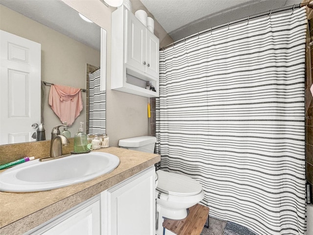 bathroom featuring vanity, a textured ceiling, and toilet