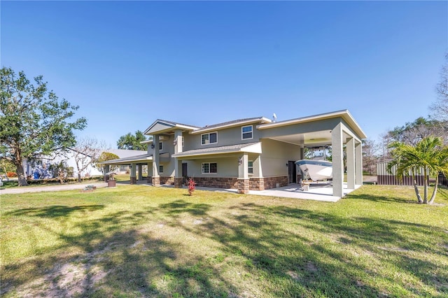 592 Ken Hubbard Rd, Terra Ceia, FL 34250 - back of house featuring an attached carport, a patio, a lawn, and stucco siding