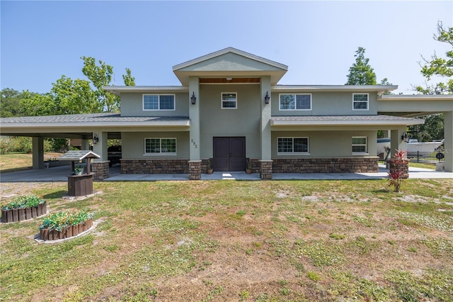 592 Ken Hubbard Rd, Terra Ceia, FL 34250 - view of front facade with stucco siding, stone siding, an attached carport, and a shingled roof