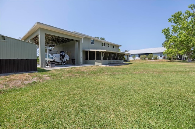 592 Ken Hubbard Rd, Terra Ceia, FL 34250 - rear view of property with a sunroom, a lawn, and a carport