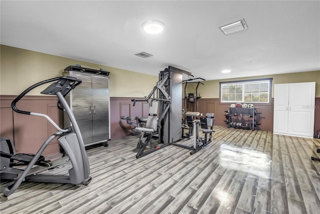592 Ken Hubbard Rd, Terra Ceia, FL 34250 - exercise area with light wood finished floors, a wainscoted wall, and a decorative wall
