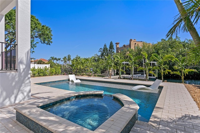 view of pool featuring a patio and a pool with connected hot tub