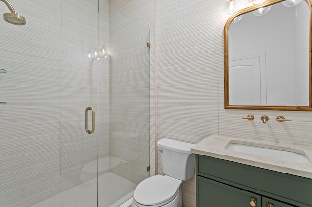 bathroom featuring toilet, vanity, a shower stall, and tile walls
