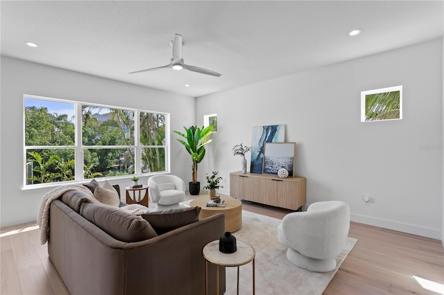 living area with recessed lighting, a ceiling fan, baseboards, and light wood-style floors