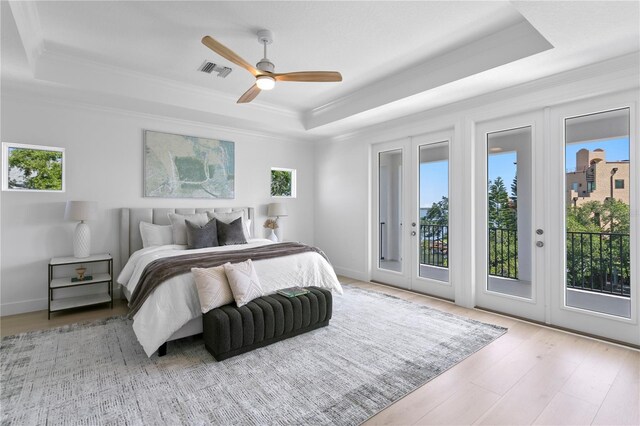 bedroom with visible vents, access to outside, multiple windows, and a tray ceiling