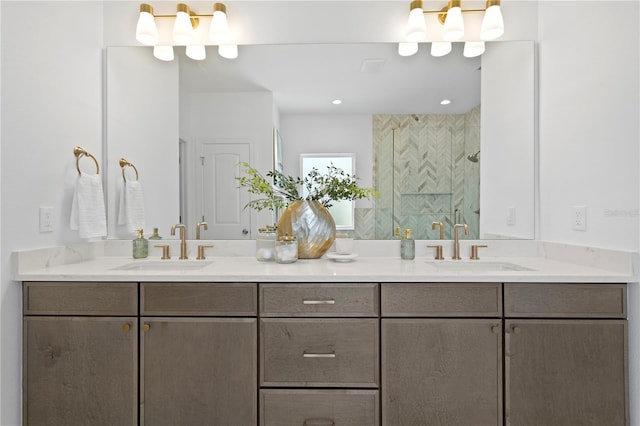 bathroom featuring double vanity, a stall shower, and a sink