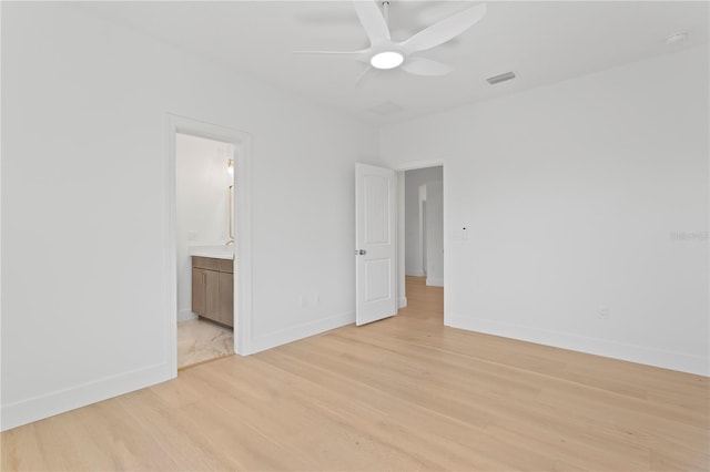 unfurnished bedroom with ensuite bathroom, visible vents, baseboards, and light wood-style floors