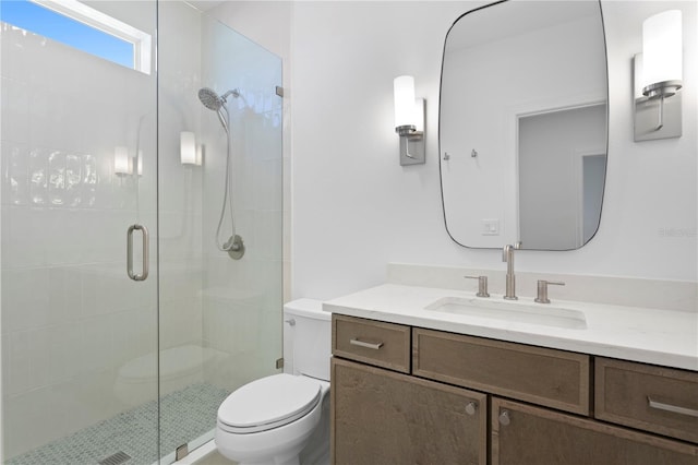full bath featuring toilet, a stall shower, and vanity