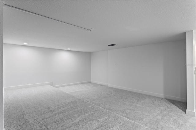 finished basement with recessed lighting, a textured ceiling, carpet flooring, and baseboards
