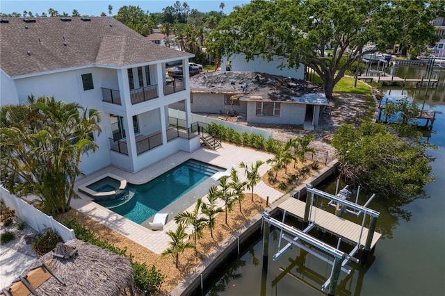 back of property with a fenced backyard, stucco siding, a patio, boat lift, and a balcony