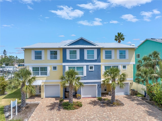 100 Windrush Blvd Unit 1, Indian Rocks Beach, FL 33785 - coastal home featuring stucco siding, decorative driveway, and an attached garage