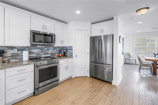 100 Windrush Blvd Unit 1, Indian Rocks Beach, FL 33785 - kitchen featuring appliances with stainless steel finishes, tasteful backsplash, white cabinetry, light wood finished floors, and recessed lighting