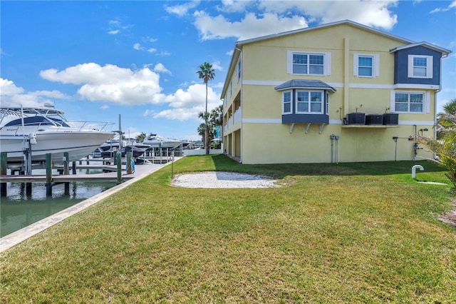 100 Windrush Blvd Unit 1, Indian Rocks Beach, FL 33785 - back of property with boat lift, cooling unit, a water view, and a yard