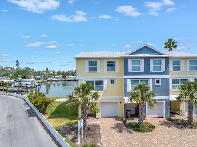 100 Windrush Blvd Unit 1, Indian Rocks Beach, FL 33785 - view of front facade featuring stucco siding, decorative driveway, a garage, a water view, and metal roof