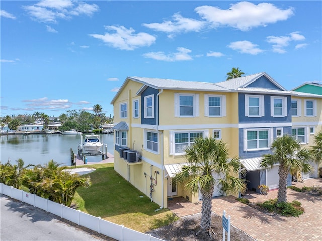 100 Windrush Blvd Unit 1, Indian Rocks Beach, FL 33785 - view of front of house featuring stucco siding, central air condition unit, a water view, boat lift, and metal roof