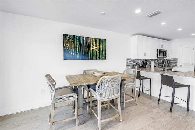 100 Windrush Blvd Unit 1, Indian Rocks Beach, FL 33785 - dining space with recessed lighting, light wood-type flooring, and baseboards