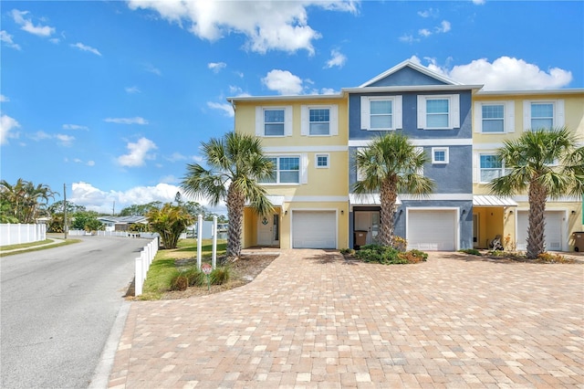 100 Windrush Blvd Unit 1, Indian Rocks Beach, FL 33785 - view of front facade featuring an attached garage, stucco siding, driveway, and fence