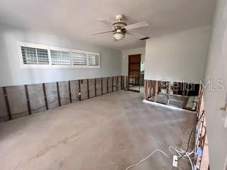 empty room with concrete flooring and a ceiling fan